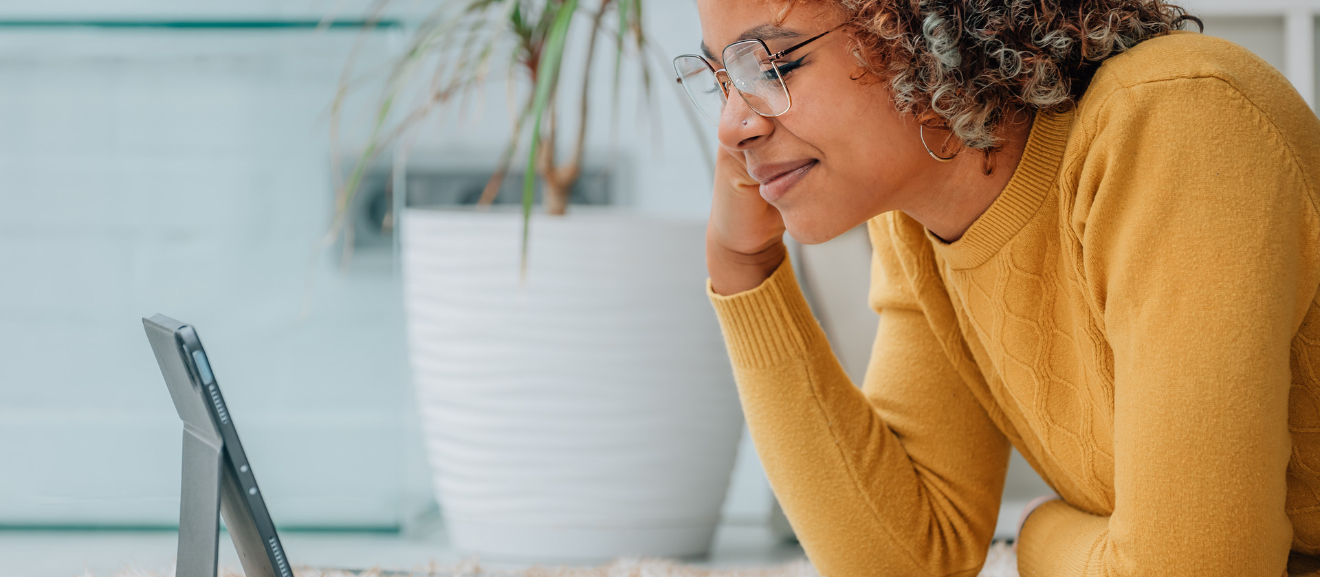 Frau gelber Pullover Brillen Tablet